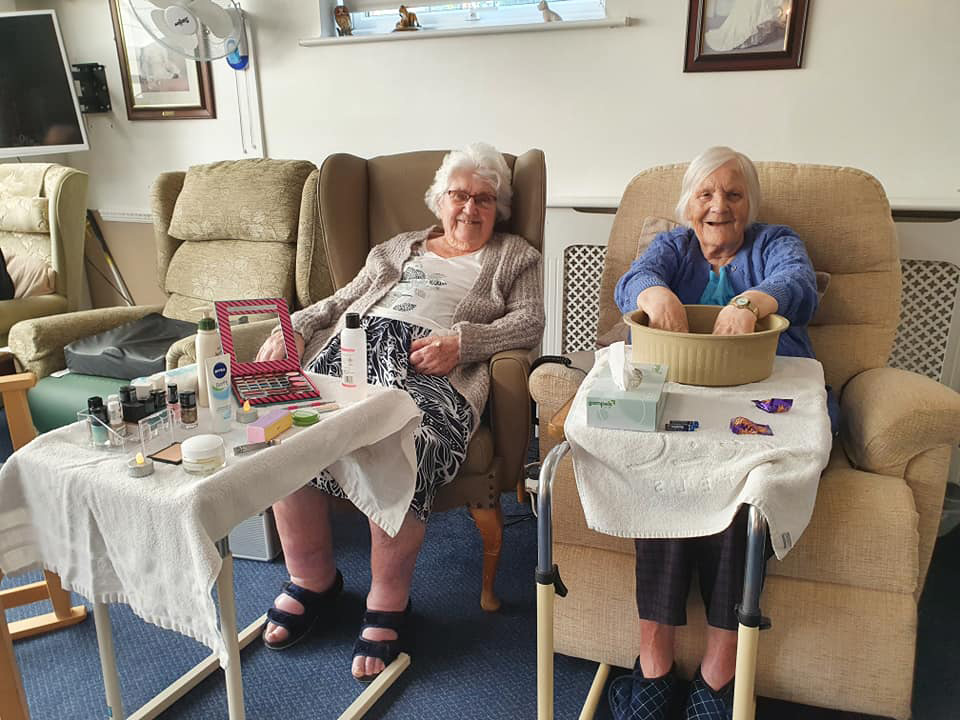Two elderly ladies getting pampered in a care home