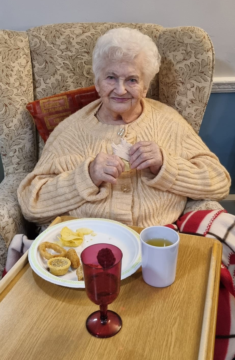 Elderly woman eating party food in a nursing home