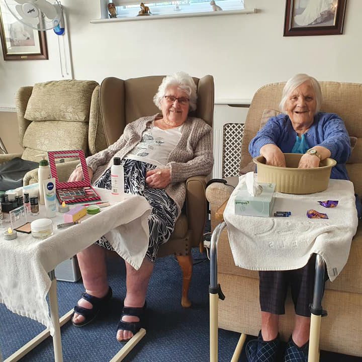Two elderly ladies getting pampered in a care home