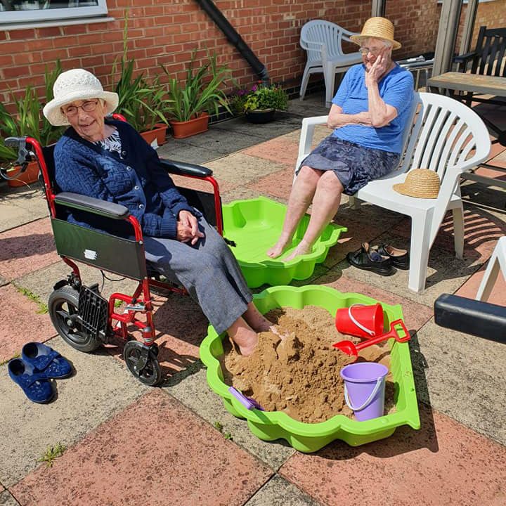 170326133_140198304773620_6166503064154426439_n Two elderly woman keeping cool in the sun with a pool and sand pit