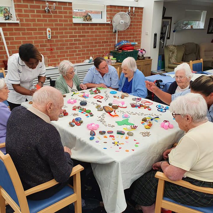 Elderly people and nursing home staff doing crafts
